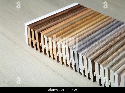 Plastic skirting board with wood texture in various colors. Design and production of flooring and molded for flooring. Skirting board for interior design of living rooms and houses. High quality photo Stock Photo