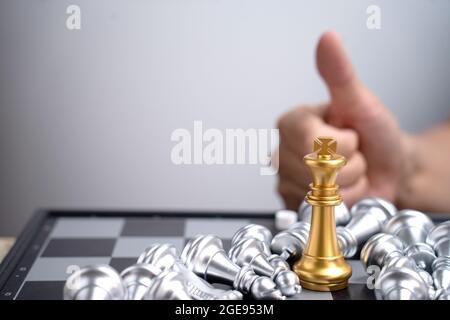 Only one gold King chess can stand in the group of falling silver chess concept business win victory in trade war battles businessman thumb up show go Stock Photo