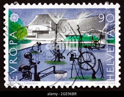 SWITZERLAND - CIRCA 1987: a stamp printed in the Switzerland shows Carnival Fountain, 1977, Sculpture by Jean Tinguely, Basel Theater, circa 1987 Stock Photo