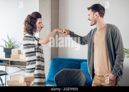 Two smiling cheerful employees giving fist bumps Stock Photo