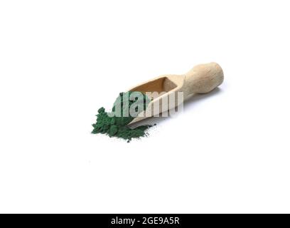 Organic spirulina algae powder in a wooden scoop isolated on white. Organic spirulina powder. Spirulina is a superfood used as a food supplement sourc Stock Photo