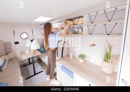 Duesseldorf, Germany. 18th Aug, 2021. Model Frieda stands in the Hobby Beachy caravan, an entry-level model with a Scandinavian-inspired interior, at a photo session for the 60th Caravan Salon at Messe Düsseldorf. The world's largest trade fair for motorhomes and caravans, the Caravan Salon, takes place from 28 August to 5 September. Credit: Rolf Vennenbernd/dpa/Alamy Live News Stock Photo