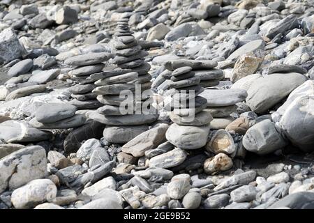 Stone towers  or stone cairns. They are placed on the rocky river bank of Rhine in Switzerland. Stock Photo