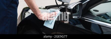 Cropped view of mechanic cleaning car with rag, banner Stock Photo
