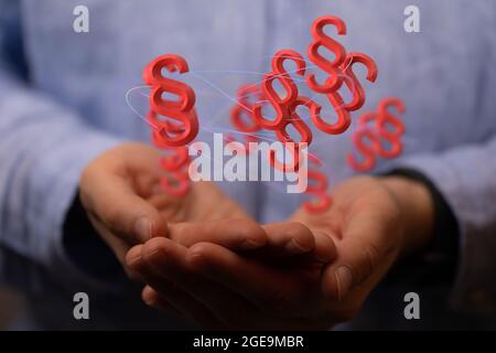 3D render of floating red paragraph law and justice symbols over a lawyer's hands Stock Photo