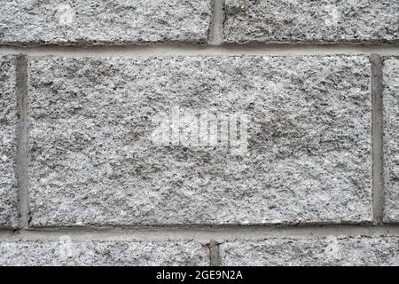 One gray embossed brick. Masonry wall, background. Stock Photo