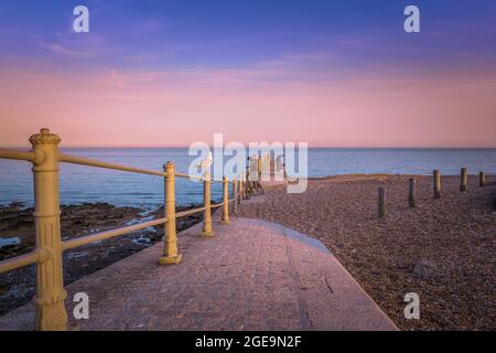 Enjoying the sunset from the wall at end of The Stade in Hastings. Stock Photo