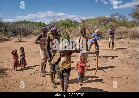 bushmen of Hadzabe  tribe train the hunt with bow and arrow, tourist making picture, Lake Eyasi, Tanzania, Africa Stock Photo