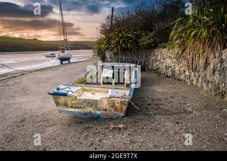 The remains of an old boat abandoned on the foreshore of the Gannel River at low tide in Newquay in Cornwall. Stock Photo