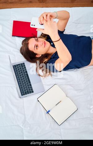 Senior bearded broadcaster standing near desk and using laptop in hands while working on project in home studio Stock Photo