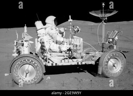 This photograph was taken during the Apollo 15 mission on the lunar surface. Astronaut David R. Scott waits in the Lunar Roving Vehicle (LRV) for astronaut James Irwin for the return trip to the Lunar Module, Falcon, with rocks and soil collected near the Hadley-Apernine landing site. The Apollo 15 was the first mission to use the LRV. Powered by battery, the lightweight electric car greatly increased the range of mobility and productivity on the scientific traverses for astronauts. It weighed 462 pounds (77 pounds on the Moon) and could carry two suited astronauts, their gear and cameras, and Stock Photo