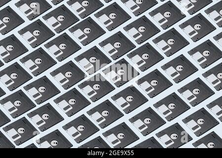 From above of old fashioned black diskettes placed in even rows on blue background Stock Photo