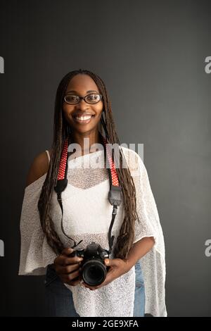 Confident African American male with dreadlocks looking at camera in dark room Stock Photo