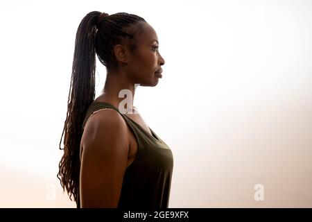 Side view of African American female with ponytail with braids on white background in studio Stock Photo