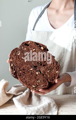 Crop faceless Woman hands holding freshly baked sourdough rye bread Crumb pan cutting in half Stock Photo