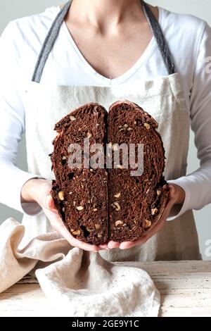 Crop faceless Woman hands holding freshly baked sourdough rye bread Crumb pan cutting in half Stock Photo