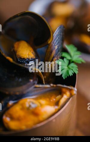 Delectable mussels with herbs in metal saucepan Stock Photo