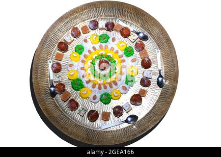Beautiful cake made of colorful rice, Decorated with dry fruits and sweets In brass plate. isolated white background Stock Photo