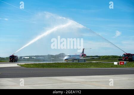 A Loganair commuter jet passing through a water arch to celebrate new route to London Southend Airport. Stock Photo