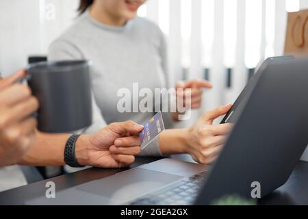 Shopping online concept a couple choosing recommended products with appealing promotions shown in online shop on a tablet device. Stock Photo