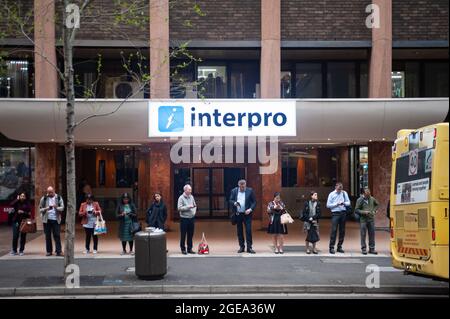 23.09.2019, Sydney, New South Wales, Australia - People stare at their phones while waiting at a bus stop in front of the Interpro employment agency. Stock Photo