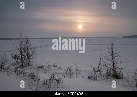 Ice fisherman's tents far out on a frozen lake in the Ural Mountains region in Russia. Stock Photo