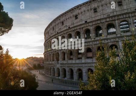 Rays of light cast an early morning glow on the Colosseum in Rome. Stock Photo