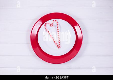 Christmas Table Setting with fir candy cane in the shape of a heart on white background, flat lay, copy space. Stock Photo