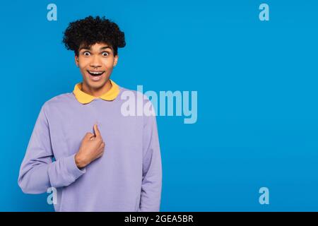 surprised african american man pointing with finger at himself isolated on blue Stock Photo