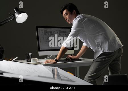 Chinese designer working on construction plan Stock Photo