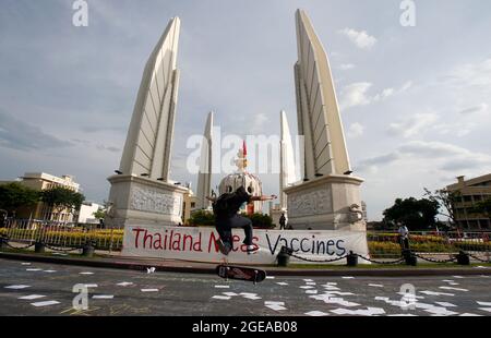 Bangkok, Thailand. 18th Aug, 2021. A protester jumps on a skateboard during the protest at the Democracy monument.Protesters demand Thailand's Prime Minister, Prayut Chan-o-cha steps down and the government be held accountable for its gross mismanagement of the Covid-19 pandemic. Credit: SOPA Images Limited/Alamy Live News Stock Photo