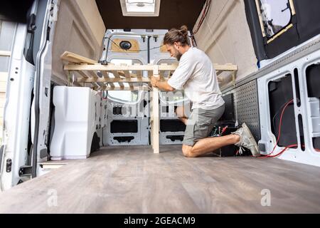Man working on the interior of his camper van Stock Photo