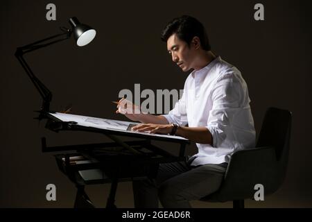 Chinese designer working on construction plan Stock Photo