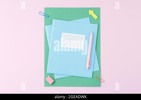 Notebook with school supplies on pink background Stock Photo