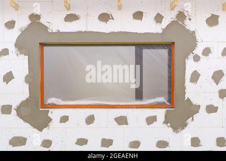 plastering work on the foam-insulated facade of a new private house. Construction and architectureof houses. Stock Photo