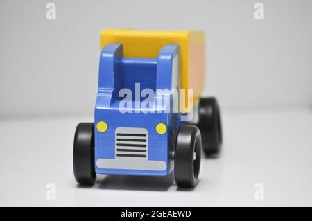 Blue and yellow wooden dumper truck - construction site toys against a white background Stock Photo