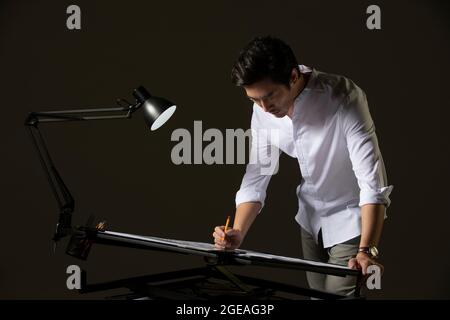 Chinese designer working on construction plan Stock Photo