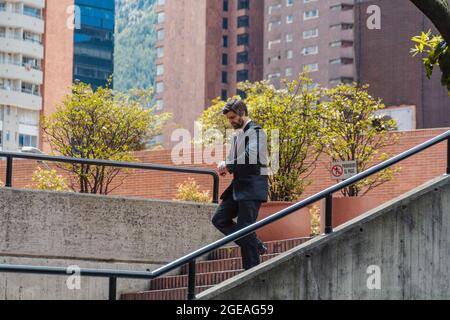 man going down stairs seeing his watch Stock Photo