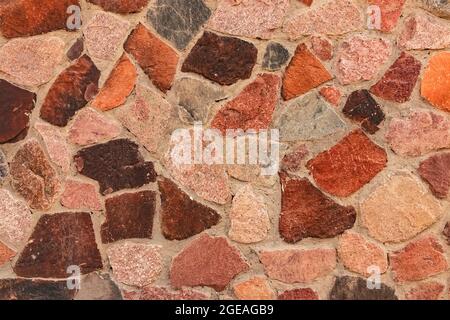 Decorative wall cladding with large granite stones. Mosaic background from large colored natural stones. Decorative cladding with multi-colored granit Stock Photo