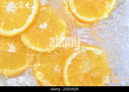 Oranges close-up in liquid with bubbles. Slices of juicy oranges in water. Close-up fresh slices of oranges on white background Stock Photo