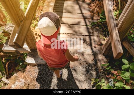 Young boy walking on a small bridge on the Ladder Creek Falls Trail in North Cascades National Park. Stock Photo