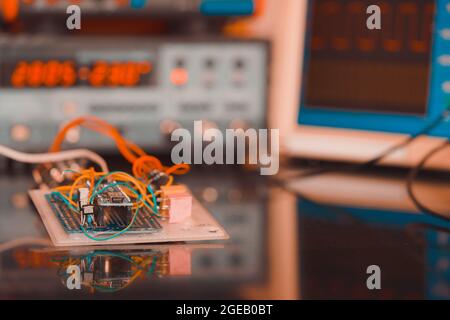 Manufacturing and setting up an electronic device in the laboratory. Soldering iron and electronic measuring instruments Stock Photo