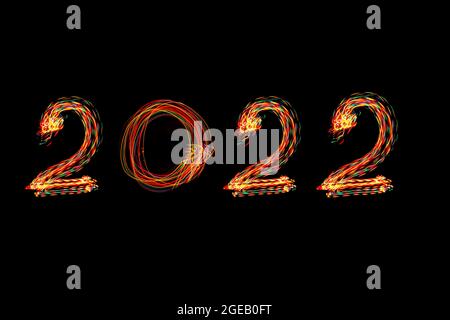 Colorful 2022 number on black background. New year 2022 coming concept. Long exposure photography. Light painting.