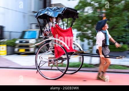 A Pulled Rickshaw Or Jinrikisha Transports Tourists Around The Sensoji ...