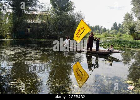 A Kashmiri Shia Muslim man waves a religious flag inside an imam badah ...