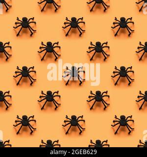 Seamless pattern of black different spiders on orange background. Halloween party pattern. Stock Photo
