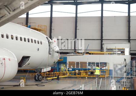 Aircraft. Passenger airplane under heavy maintenance in airport hangar indoors in the daytime Stock Photo