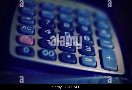 Close up of a modern calculator with a blue light, concept of business and economy. Stock Photo