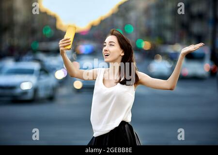 Female blogger makes video call from city street. Stock Photo