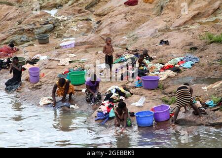 Women are seen washing their clothes in Lilongwe river as the children play. Malingunde, Malawi. Stock Photo